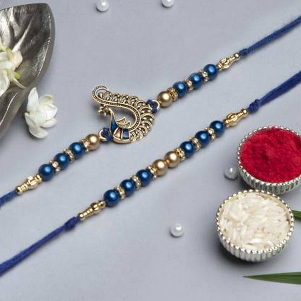 eCraftIndia Set of 2 Blue & Golden Pearls and Peacock Designer Rakhis with Roli Chawal Pack