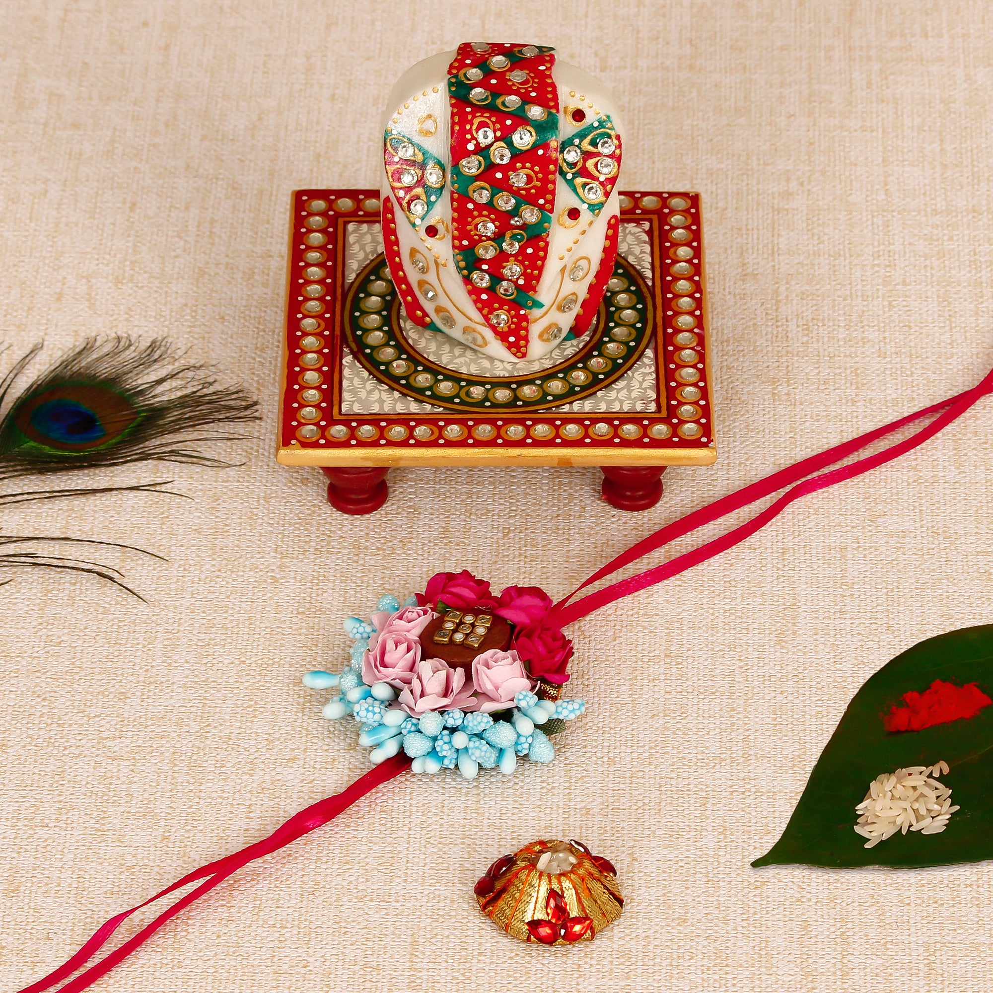 Designer Floral Rakhi with Lord Ganesha on Kundan Studded Marble Chowki and Roli Tikka Matki