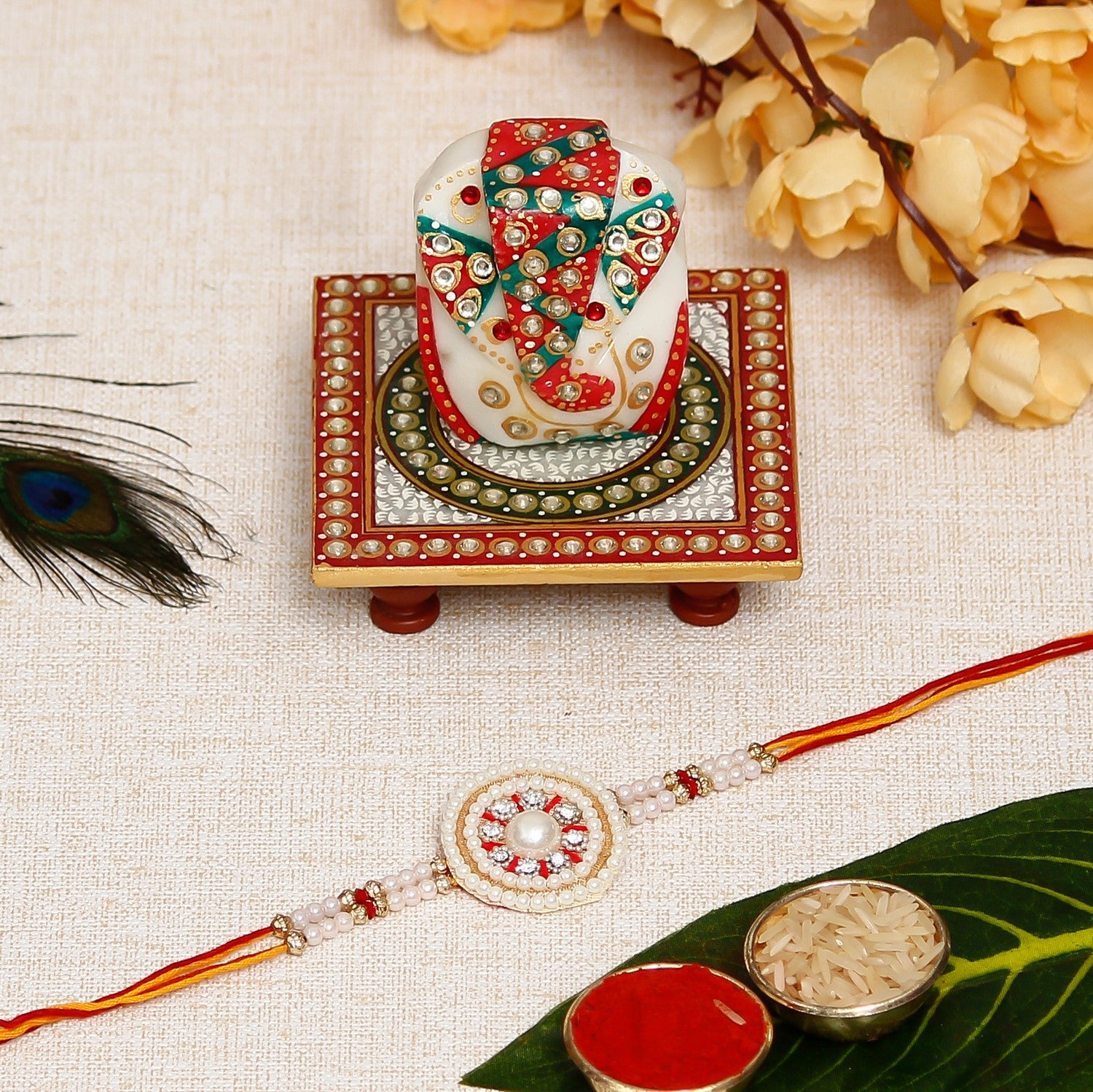 Desginer Stone and Pearl Rakhi with Lord Ganesha on Kundan Studded Marble Chowki and Roli Chawal Pack